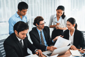 Group of business associates meeting around a table, taking notes